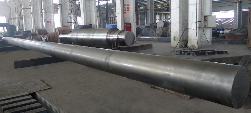 A 16-meter long, precision-finished steel rotor shaft being inspected in a manufacturing facility, showcasing its smooth, polished surface ready for final assembly.