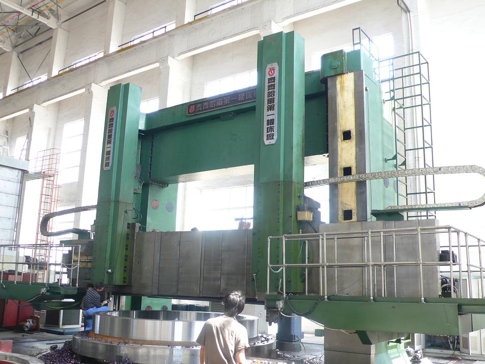 The massive DVT630 double-column CNC vertical lathe, showing its large crossbeam and 100-ton capacity worktable.
