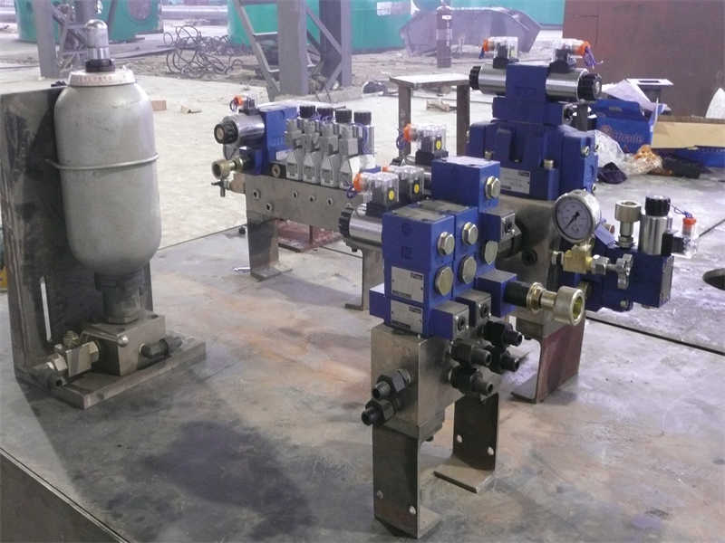 A custom-engineered hydraulic valve manifold block for an isostatic press, showing its multiple integrated valve ports for controlling hydraulic circuits.