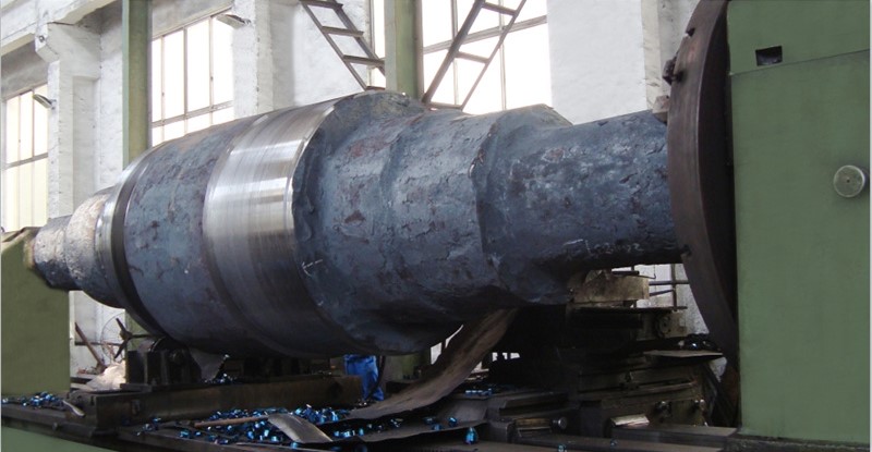 A massive forged steel work roll for a steel rolling mill being precision-turned on a heavy-duty CNC lathe in our manufacturing facility.